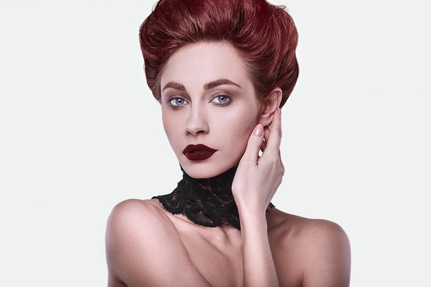 Mulher ruiva elegante beleza com penteado e usando colar de jóias