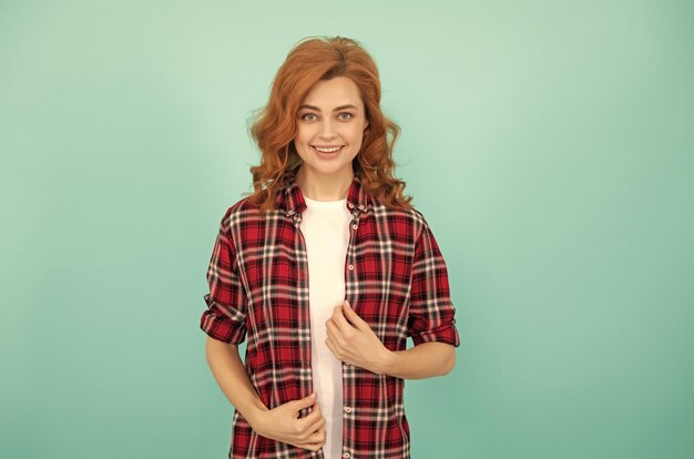 Mulher ruiva feliz em camisa quadriculada expressa emoções positivas senhora sorridente com cabelo encaracolado