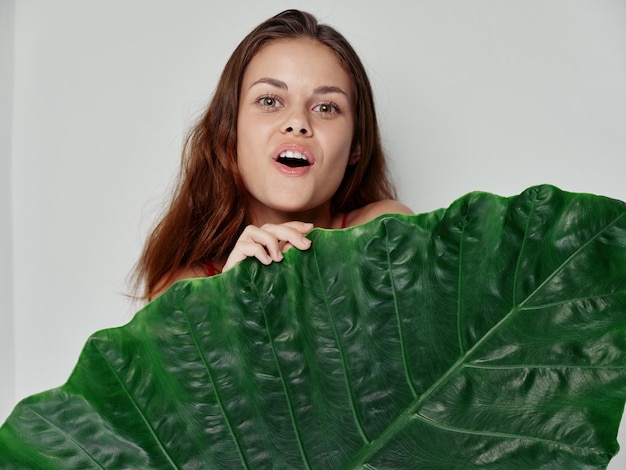 Foto mulher ruiva folha verde ombros bonitos e nus close-up foto de alta qualidade