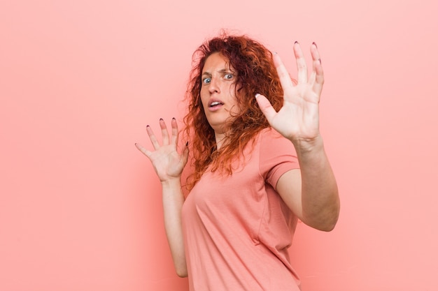 Mulher ruiva natural e autêntica jovem sendo chocada devido a um perigo iminente