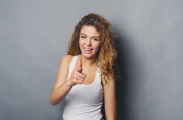 Mulher ruiva sorridente, apontando para a câmera. Garota atraente flertando com você, conceito de escolha certa, pôster de motivação