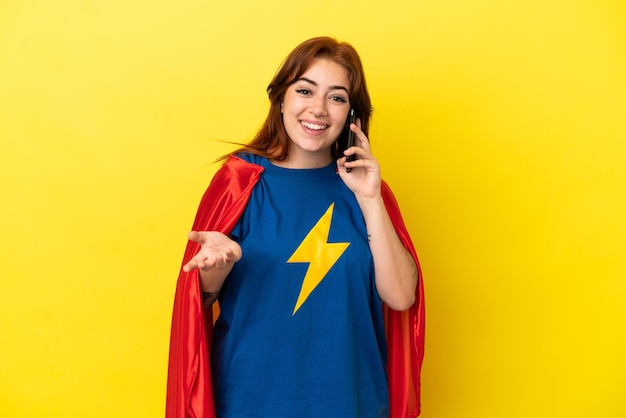 Mulher ruiva super-heroína isolada em fundo amarelo, conversando com alguém ao telefone celular