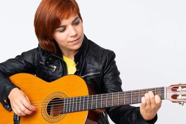 Mulher ruiva tocando violão