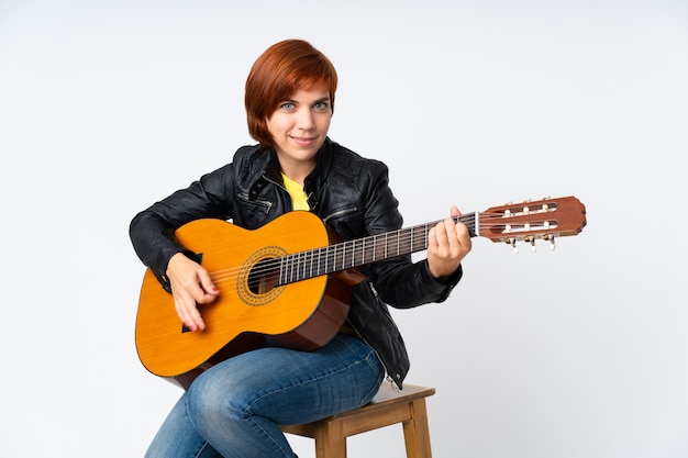 Mulher ruiva tocando violão