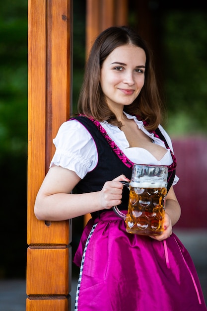 Foto mulher russa sexy com vestido bávaro segurando canecas de cerveja