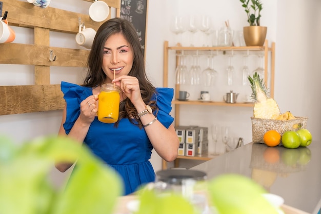 Mulher saboreando um suco de laranja fresco no balcão de uma cafeteria