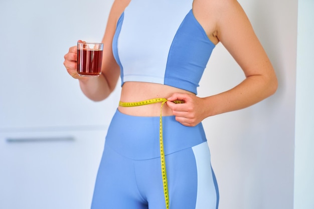 Mulher saudável esportiva fitness bebendo chá de ervas para perda de peso e corpo esbelto