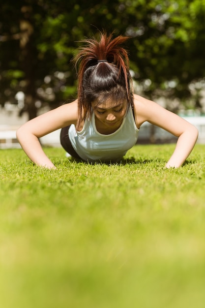 Foto mulher saudável, fazendo flexões no parque