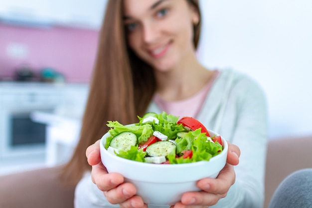 Mulher saudável vegan segurando uma tigela de salada de legumes frescos. Dieta orgânica equilibrada e alimentação limpa