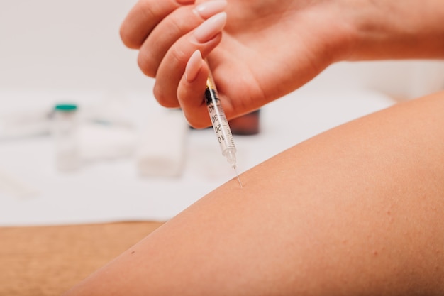 Foto mulher se aplicando uma injeção contra diabetes