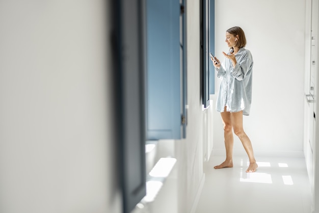 Mulher se comunica por telefone em casa