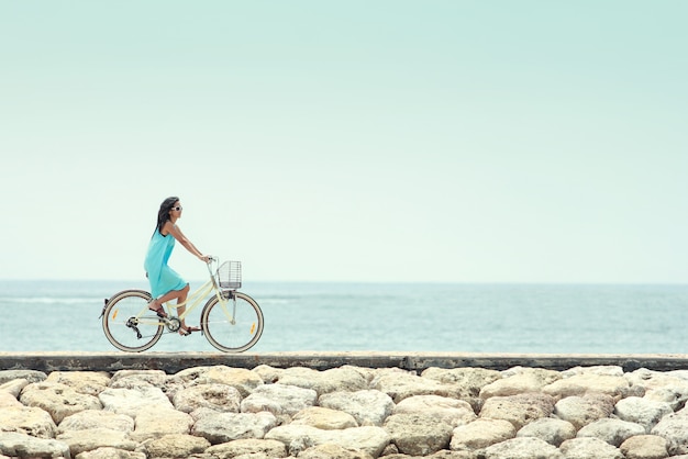 Mulher se divertindo andando de bicicleta na praia