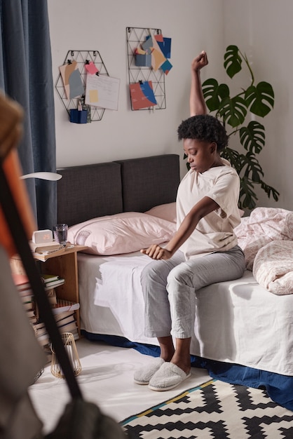 Mulher se espreguiçando depois de dormir no quarto