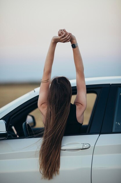 Mulher se inclinando para fora da janela do carro