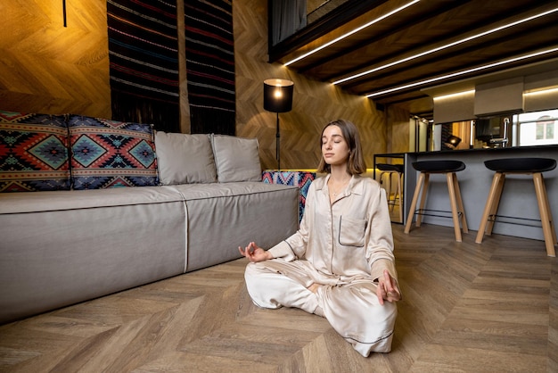 Mulher se sentindo calma enquanto medita em casa
