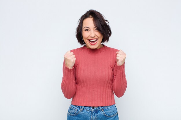 Mulher se sentindo chocado, animado e feliz, rindo e comemorando o sucesso, dizendo uau!