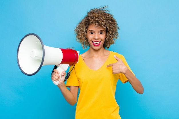 Mulher se sentindo feliz, surpresa e orgulhosa, apontando para si mesma com um olhar animado e espantado