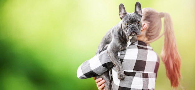 Mulher segura cachorro buldogue francês passa tempo de lazer com amigos animais leais fundo da natureza amizade humanos e animais