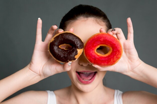 Mulher segura, calorie, bomba, donut, ligado, cinzento, fundo