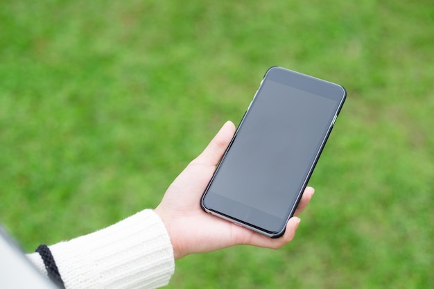 Mulher segura com telefone celular sobre fundo verde