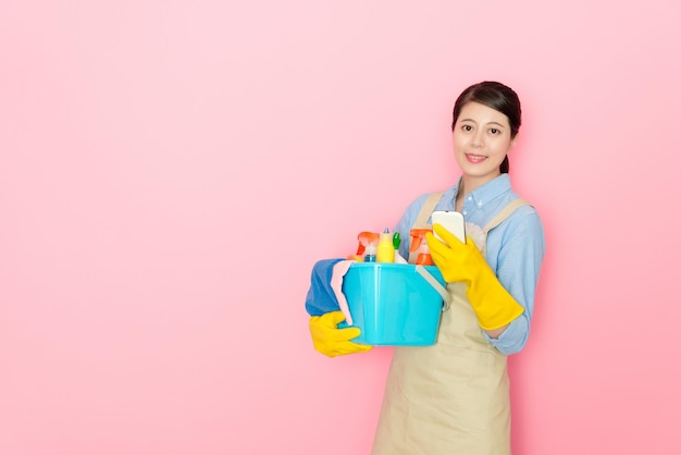 mulher segura ferramentas de limpeza e usando smartphone mostrando serviço de limpeza online