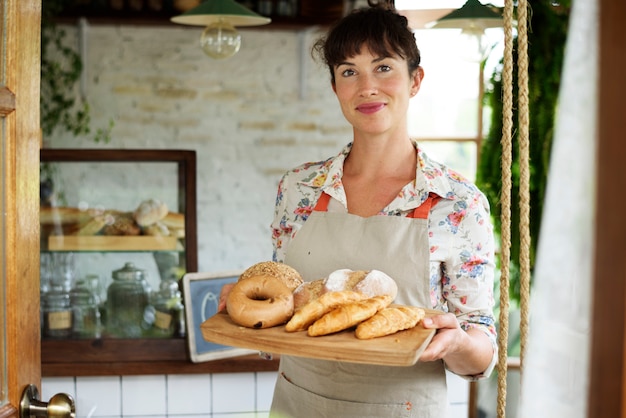 Mulher segura, fresco, assado, pão, ligado, madeira, bandeja