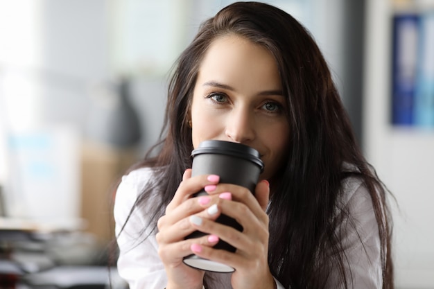 Foto mulher segura moog de papel preto com café