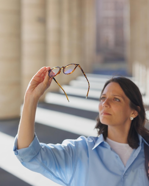 Mulher segura óculos nas mãos lentes de contato ópticas para problemas de visão de saúde ocular tratamento da retina