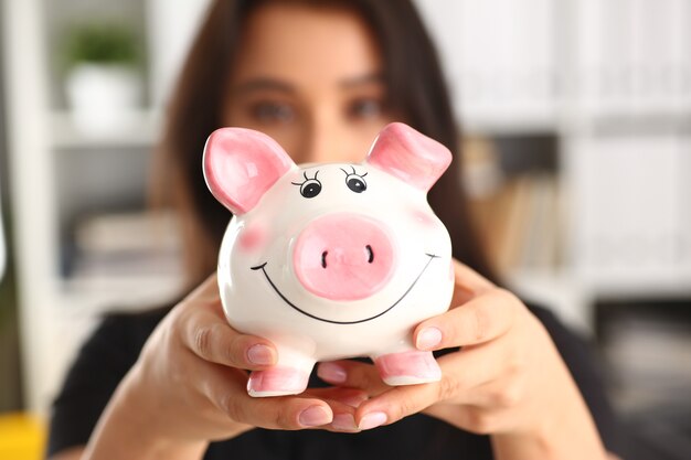 Mulher segura piggybank nos braços