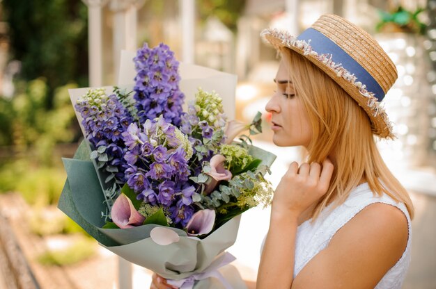 Mulher segura um buquê de callas e delphinium