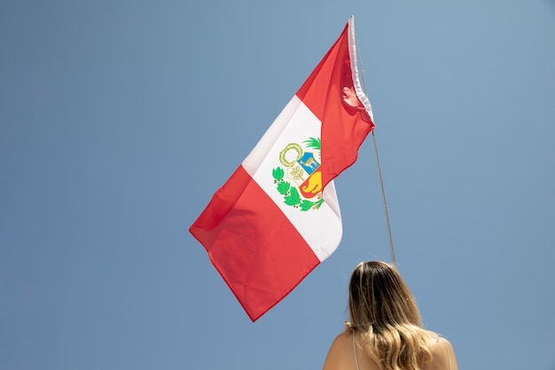 Foto mulher segurando a bandeira do peru