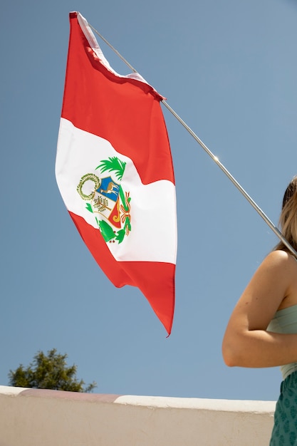 Foto mulher segurando a bandeira do peru