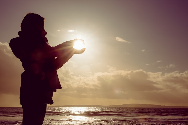 Mulher segurando a luz do sol