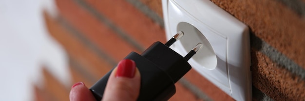 Mulher segurando a mão e inserindo plugue no conceito de soquete de muitos tipos de equipamentos elétricos