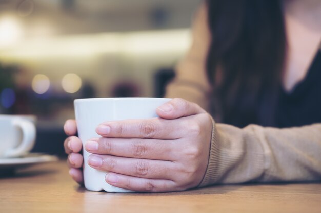 mulher segurando a xícara de café