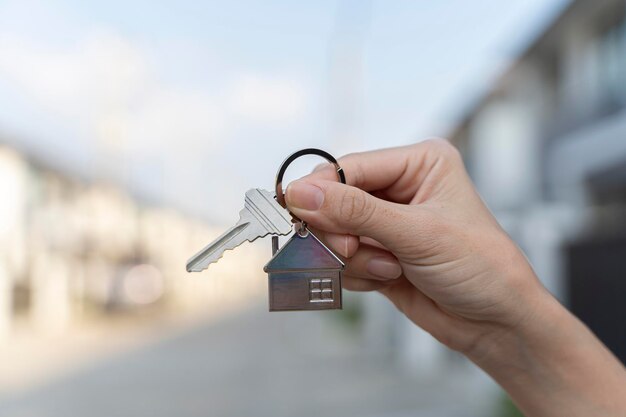 Mulher segurando as chaves da casa ao ar livre fechada com espaço para texto agente imobiliário