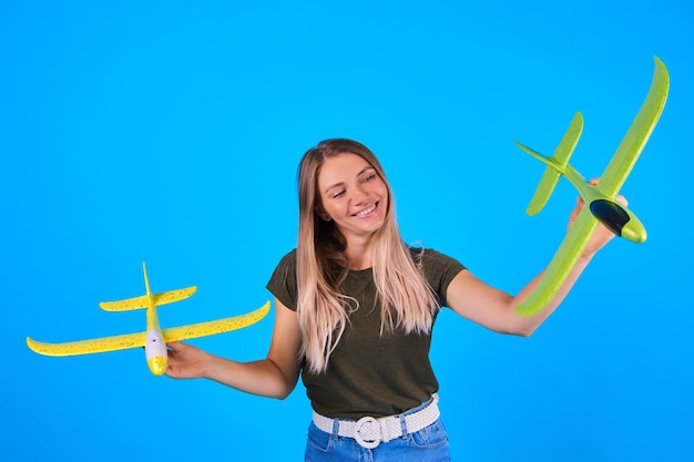 Mulher segurando avião de brinquedo no fundo do céu azul Conceito de viagem aérea de escolher as melhores linhas aéreas