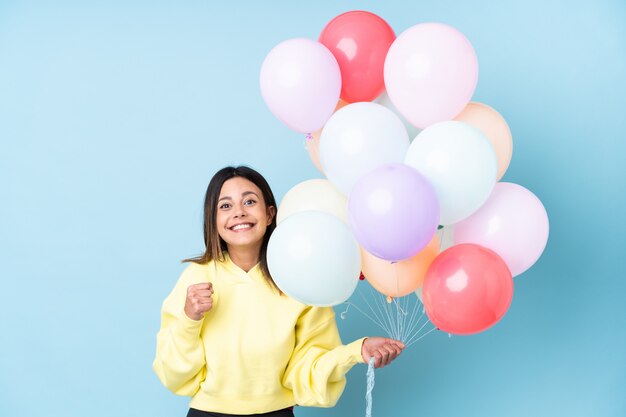 Mulher segurando balões em uma festa comemorando uma vitória