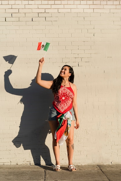 Foto mulher segurando bandeira mexicana na rua