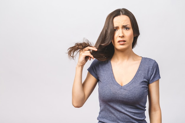 Mulher segurando cabelo danificado com a mão