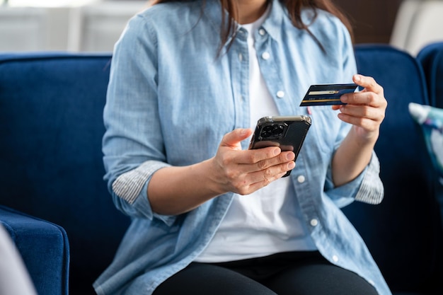 Mulher segurando cartão de crédito e usando smartphone em casa empresária fazendo compras online ecommerce internet banking gastando dinheiro trabalhando em casa conceito