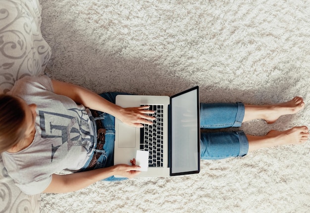 Mulher segurando cartão de crédito para compras online Pagamento e trabalhando em um laptop Mulher usando um laptop