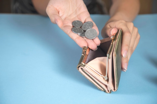 Mulher segurando carteira com moedas