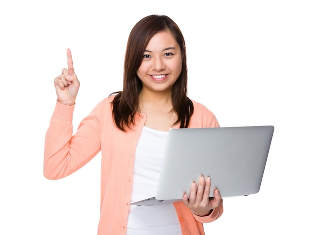 Mulher segurando com laptop e dedo apontando para cima