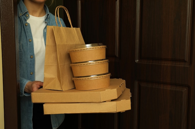 Mulher segurando contêineres de entrega de comida para viagem