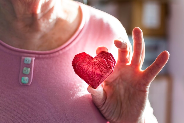 Foto mulher segurando coração impresso em 3d vermelho, amor e gratidão pela saúde e caridade ou tecnologia
