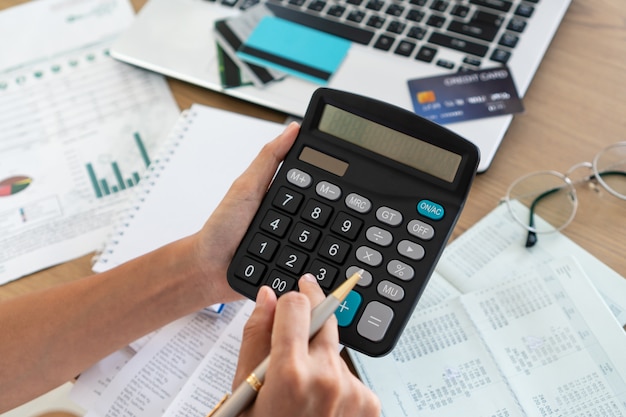 Mulher segurando e usando calculadora, conta e salvando o conceito.