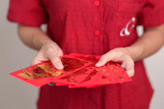 Mulher segurando envelope vermelho chinês com coelho dourado e palavra de bênção presente em dinheiro para feliz feriado do Ano Novo Lunar A frase chinesa significa felicidade saudável Sorte e riqueza
