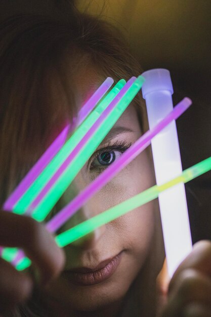 Foto mulher segurando equipamentos coloridos à noite