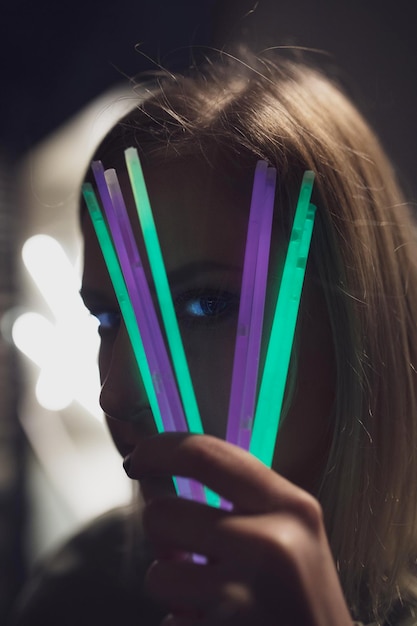 Foto mulher segurando equipamentos coloridos à noite